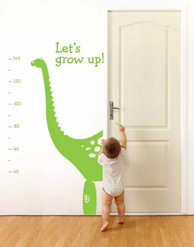 Baby in front of a closed door, trying to reach the keyhole with key